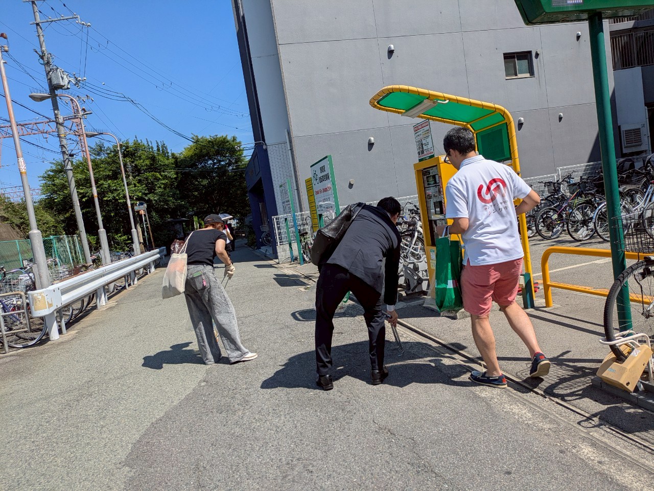 朝の駅前で清掃をする参加者